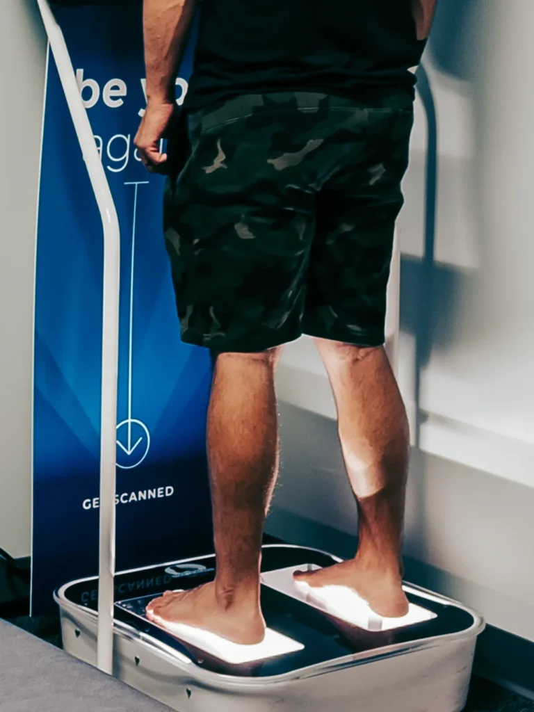 Close-up of bare feet on a 3D laser foot scanner mapping arch shape and pressure