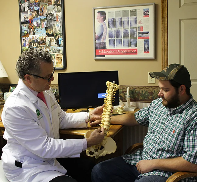 Dr. Brent Ungar using a spine model to explain a patient’s condition at Belden Village Chiropractic and Wellness Center in Canton, OH