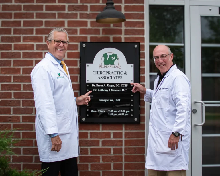 Dr. Brent Ungar and Dr. Anthony Gatelaro beside the office sign at Belden Village Chiropractic and Wellness Center in Canton, OH